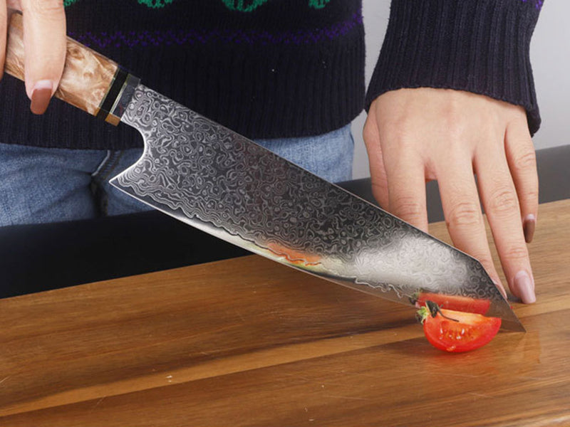Side view of the Japanese knife cutting through tomato showing its sharpness
